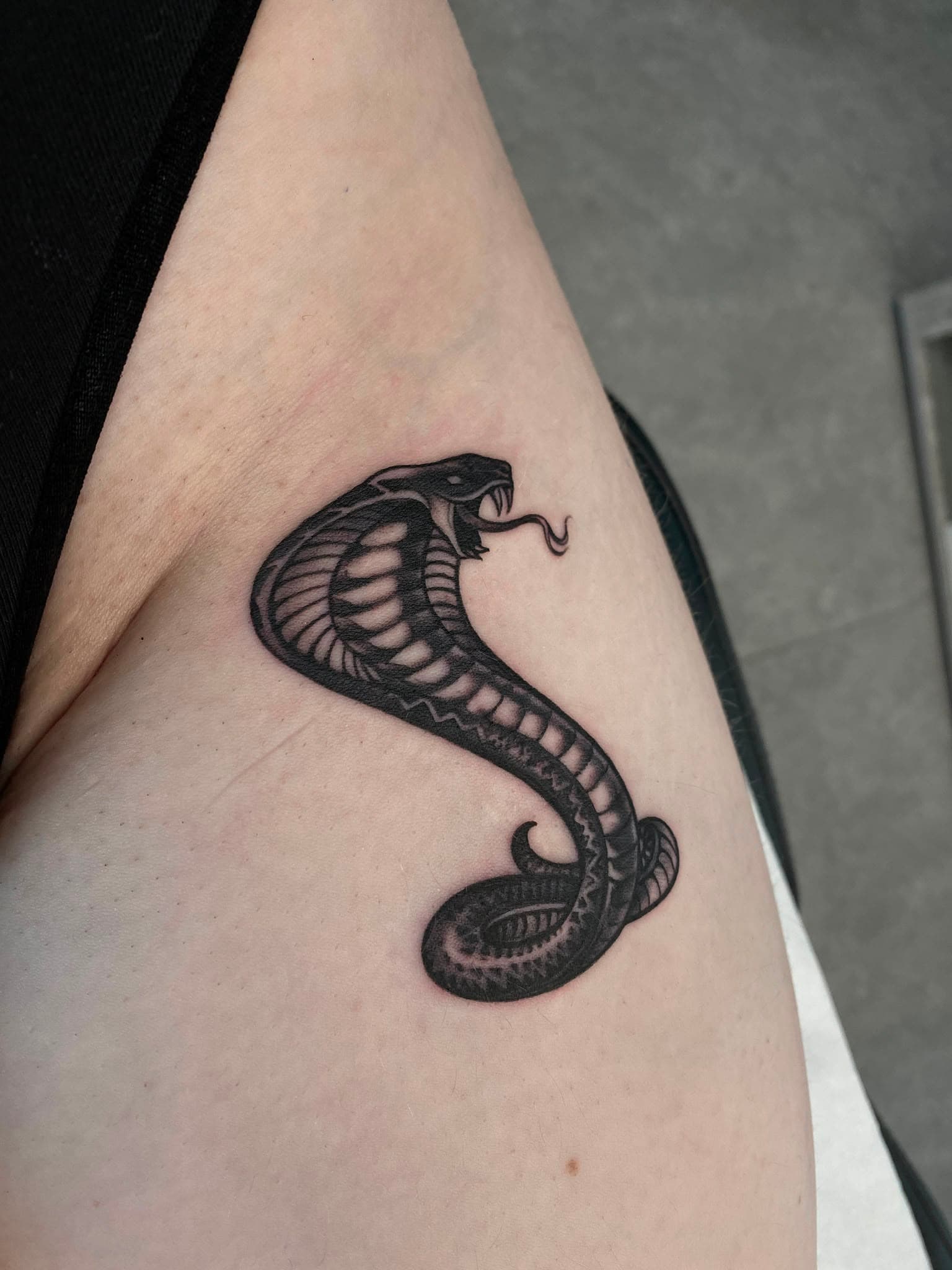 Kobra-Tattoo am Oberarm